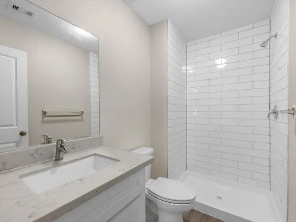 a bathroom with a granite countertop sink toilet and shower