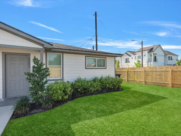 a front view of a house with a garden and yard