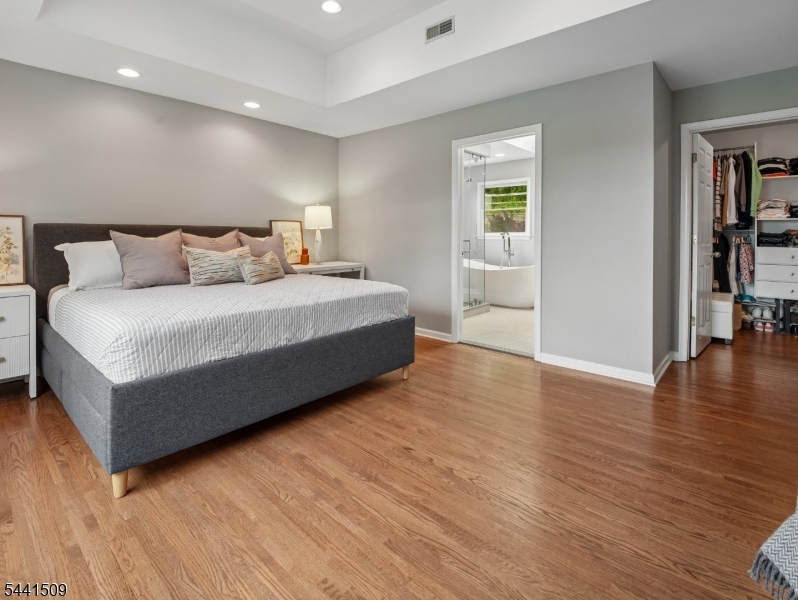 610 River Road Chatham, NJ 07928 - Photo 16 of 42 a spacious bedroom with a bed and a wooden floor