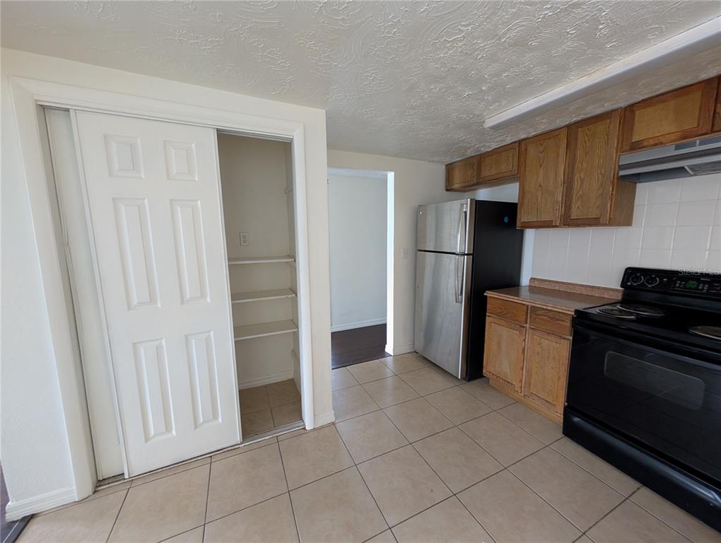 3227 Darlington Road Holiday, FL 34691 - Photo 5 of 15 a kitchen with a refrigerator and a stove top oven