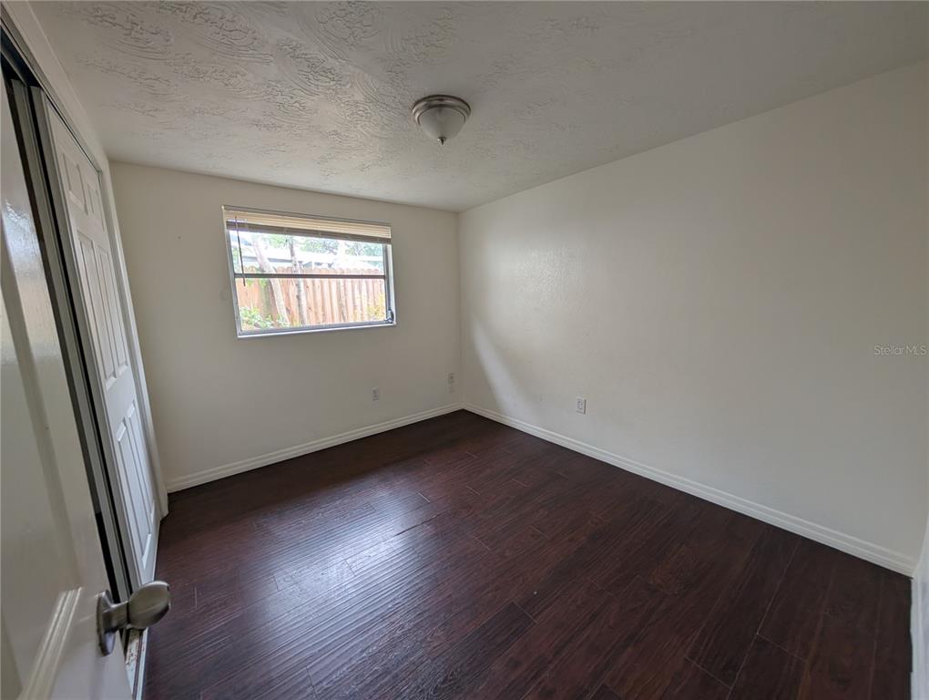 3227 Darlington Road Holiday, FL 34691 - Photo 9 of 15 an empty room with wooden floor and windows