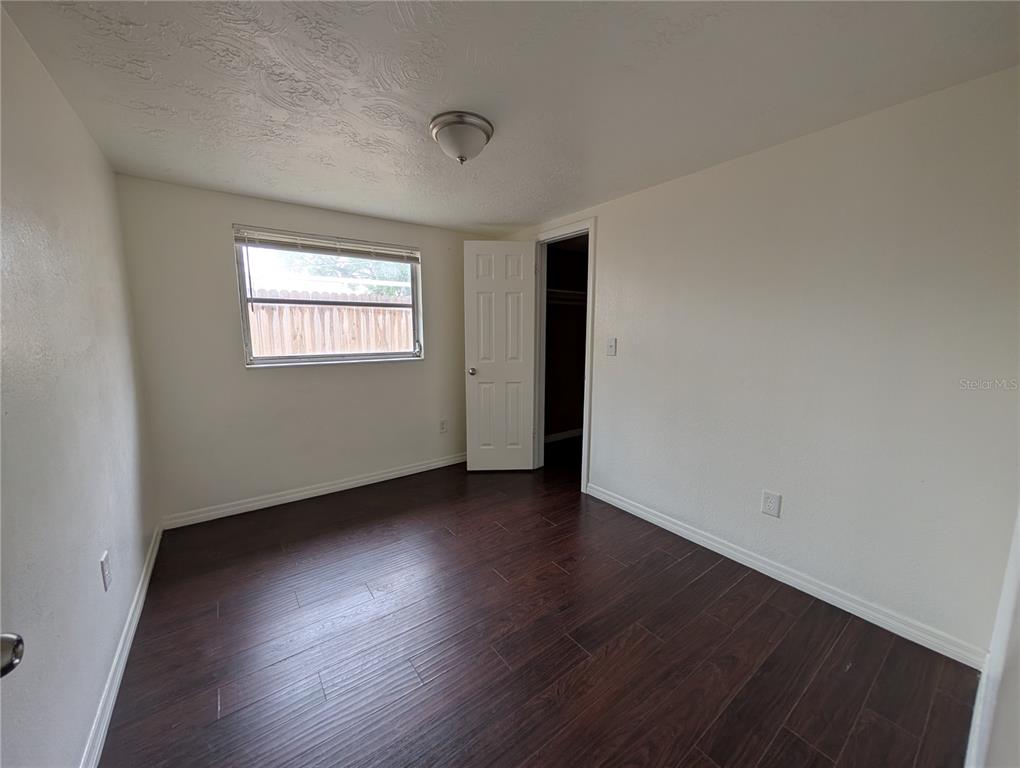 3227 Darlington Road Holiday, FL 34691 - Photo 10 of 15 an empty room with wooden floor and windows