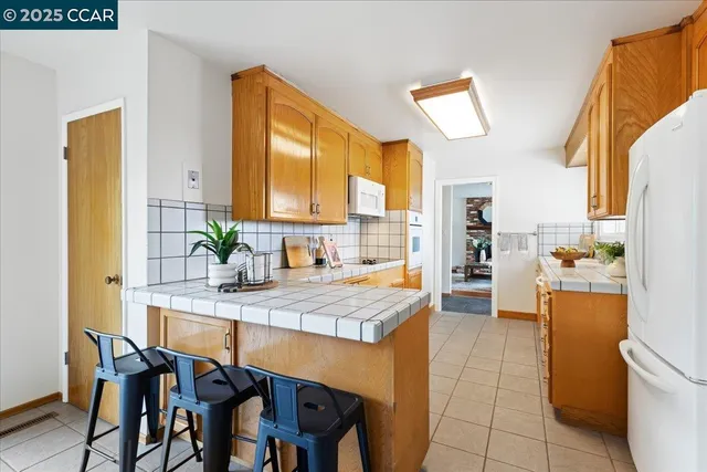 a kitchen with a table chairs refrigerator and cabinets
