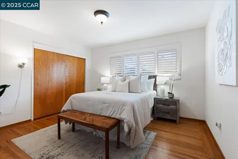 a bedroom with a bed table and a window