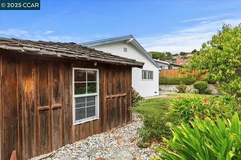 a view of a house with a window and wooden fence