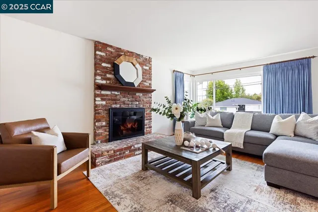 a living room with furniture a fireplace and a floor to ceiling window