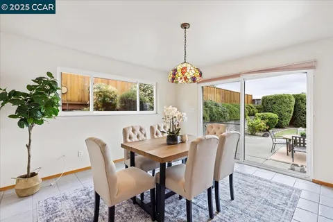 a dining room with furniture a chandelier and window