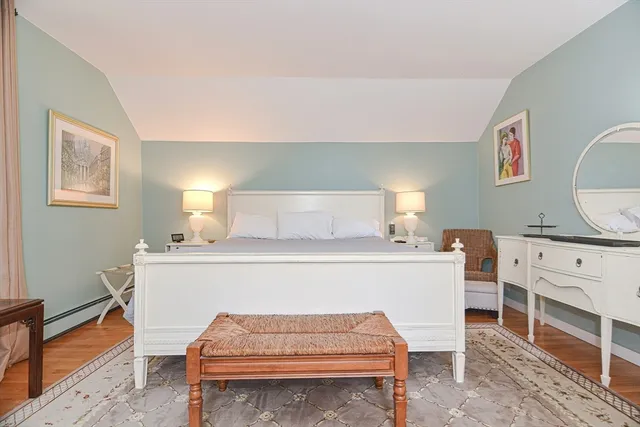 a bedroom with a bed and a painting on the wall