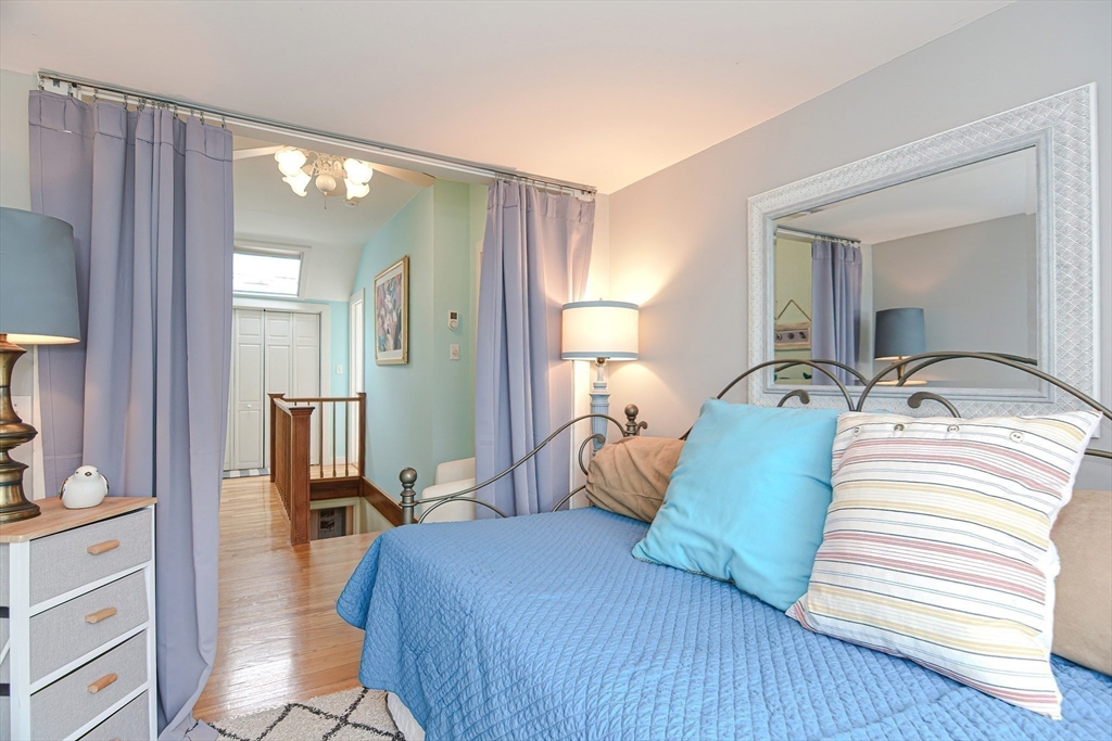 93 Granite Street, Unit 1 Rockport, MA 01966 - Photo 21 of 24 a bedroom with a bed and wooden floor