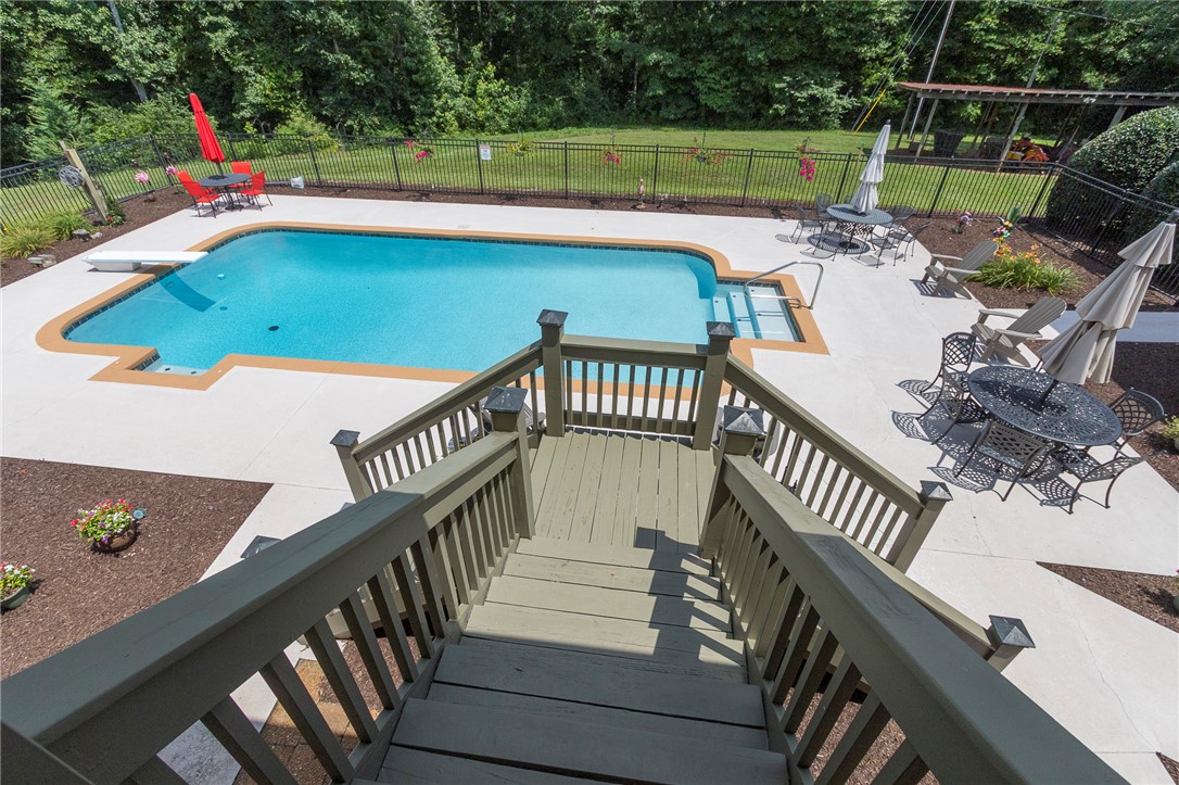 911 State Rd S-4-203 Belton, SC 29627 - Photo 38 of 49 A refreshing in-ground pool awaits, surrounded by ample patio space for outdoor enjoyment and dining.