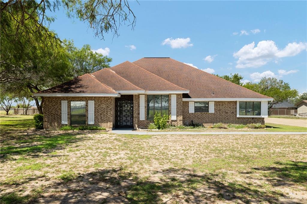 Ranch-style house with brick siding and a front lawn