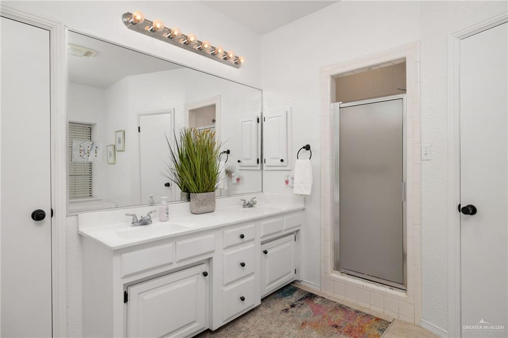 3309 South McColl Road Edinburg, TX 78539 - Photo 12 of 27 Bathroom with a shower stall, double vanity, and light tile patterned flooring