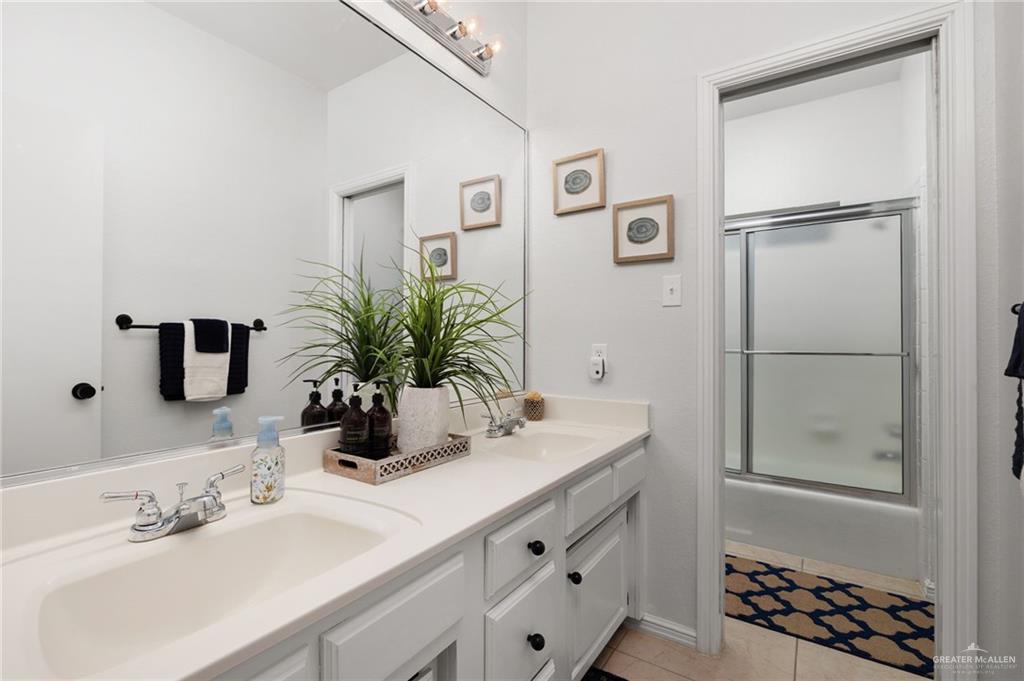 3309 South McColl Road Edinburg, TX 78539 - Photo 15 of 27 Full bathroom with light tile patterned flooring, combined bath / shower with glass door, and double vanity