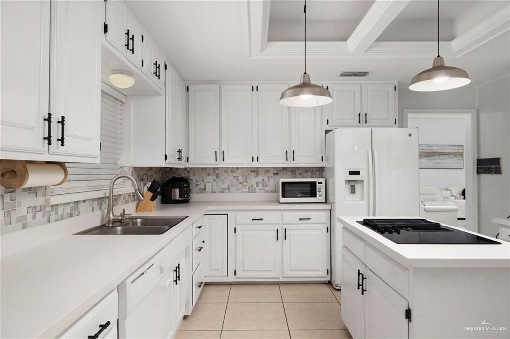 3309 South McColl Road Edinburg, TX 78539 - Photo 10 of 27 Kitchen featuring light countertops, tasteful backsplash, light tile patterned floors, white cabinets, and white appliances