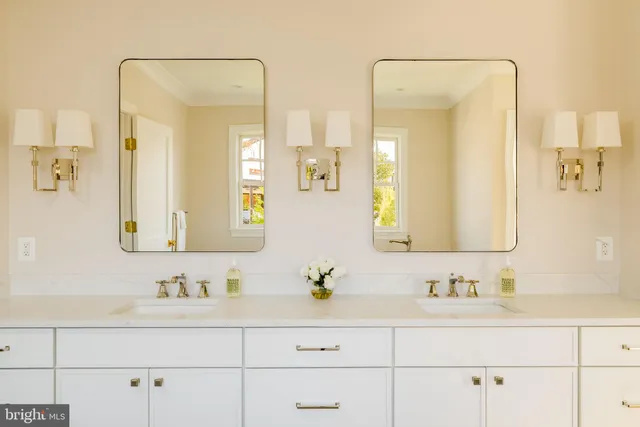 a bathroom with double vanity sinks and a mirror
