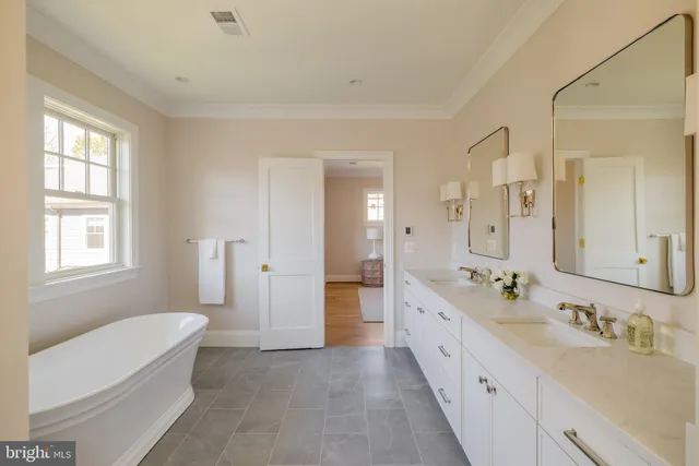 a spacious bathroom with a double vanity sink a large mirror and a bathtub