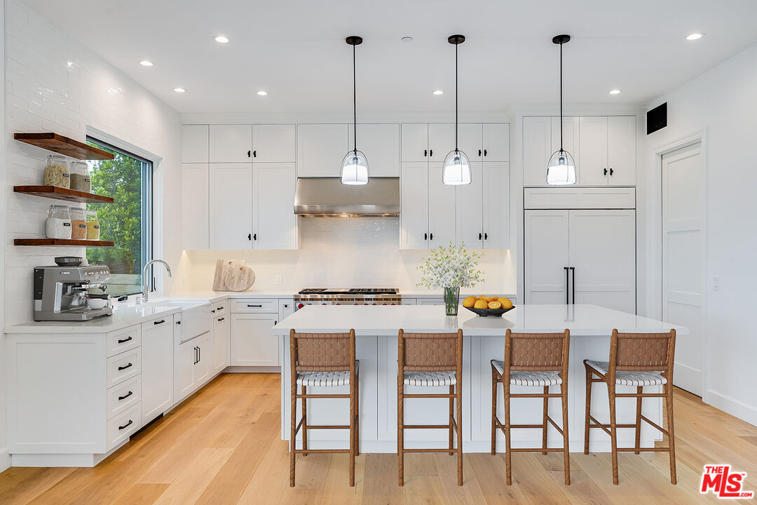 26575 Ocean View Drive Malibu, CA 90265 - Photo 6 of 39 a large kitchen with stainless steel appliances kitchen island granite countertop a stove a sink a dining table and chairs