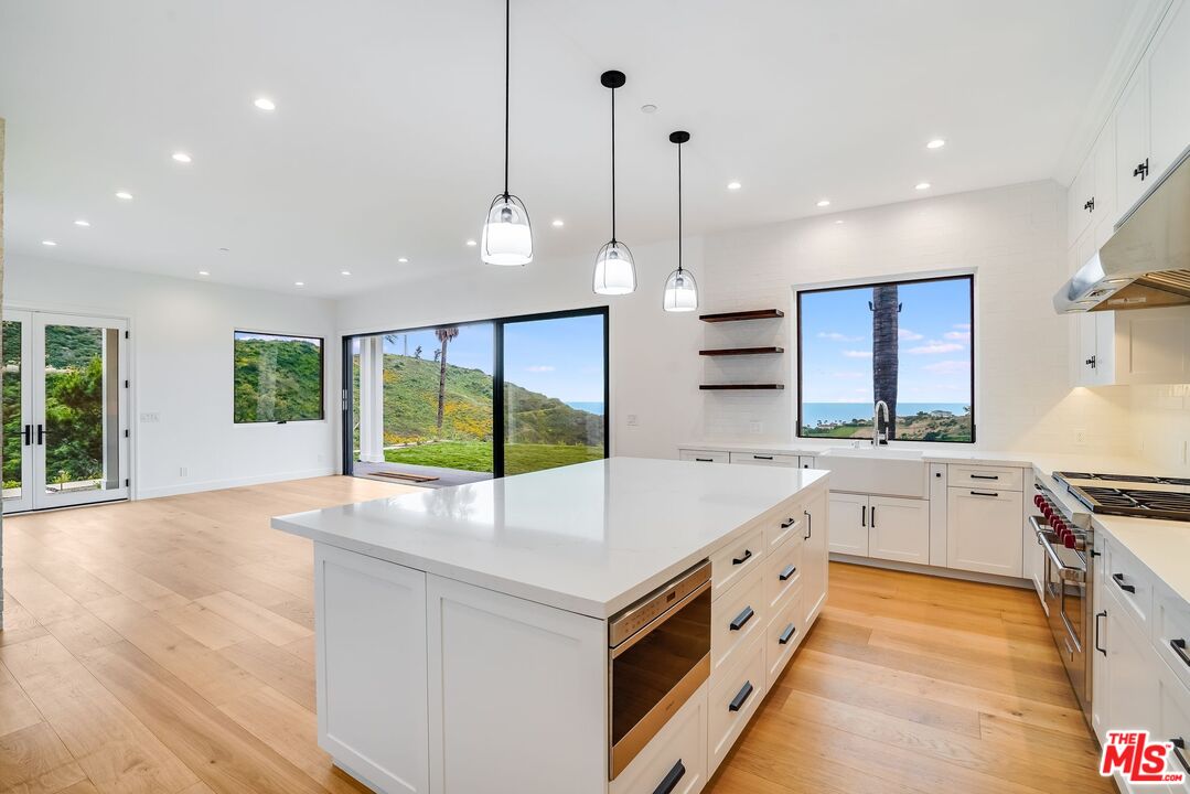 26575 Ocean View Drive Malibu, CA 90265 - Photo 7 of 39 a large kitchen with stainless steel appliances granite countertop a stove and a sink with large wooden floors