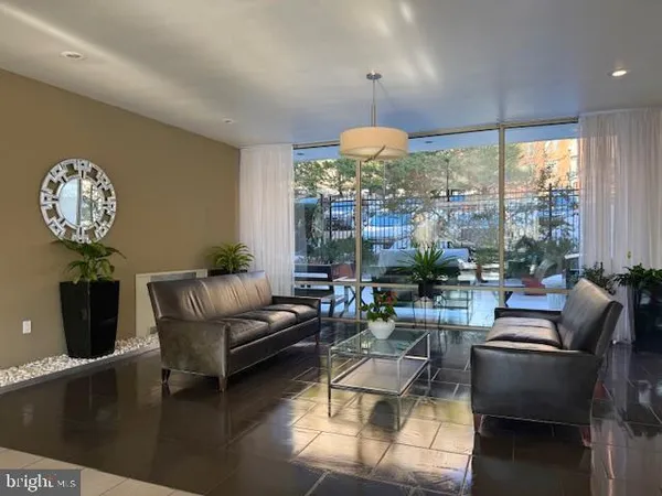 a living room with furniture a chandelier and a large window