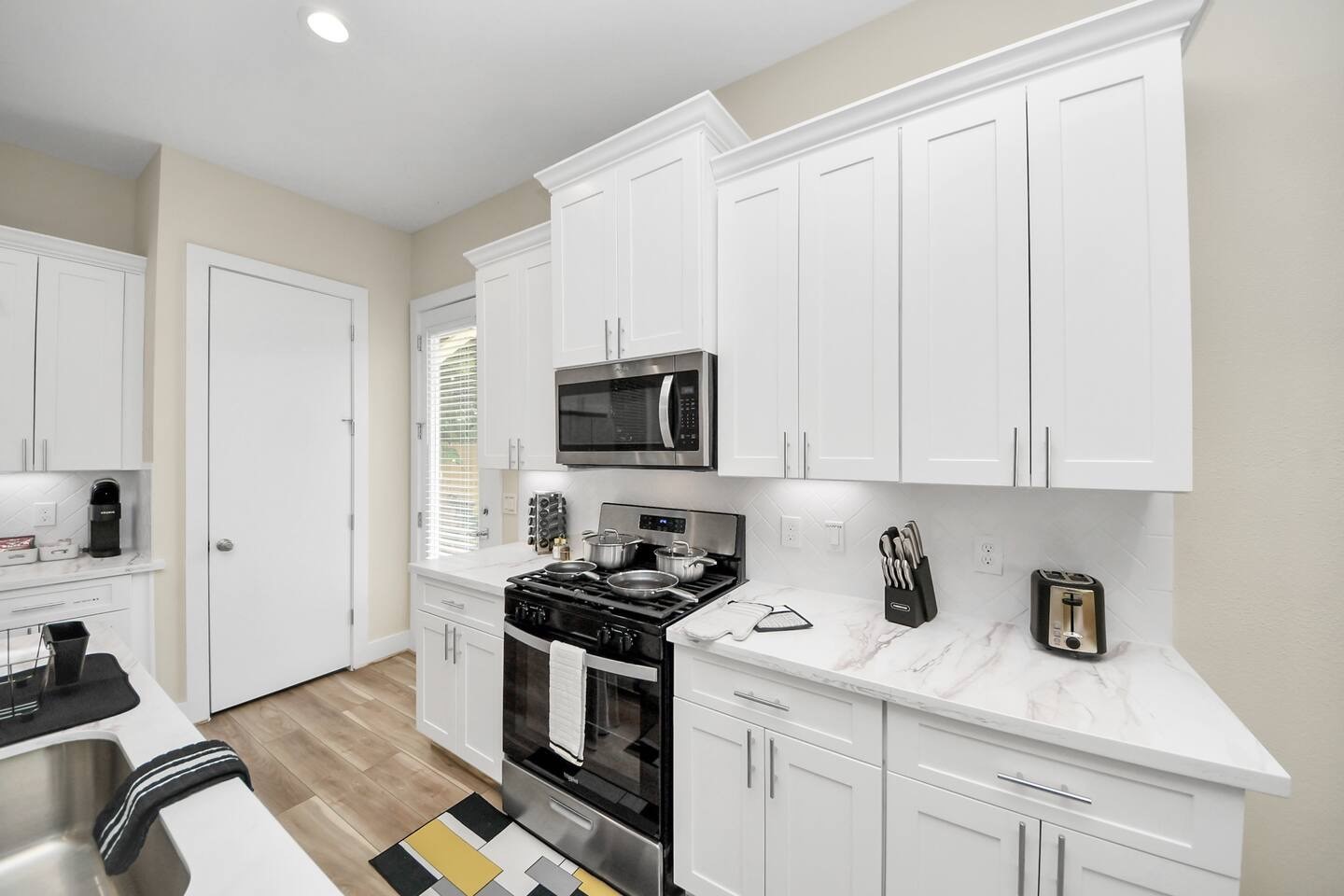 5935 Beall Street, Unit D Houston, TX 77091 - Photo 14 of 50 a kitchen with stainless steel appliances granite countertop a sink a stove and a microwave