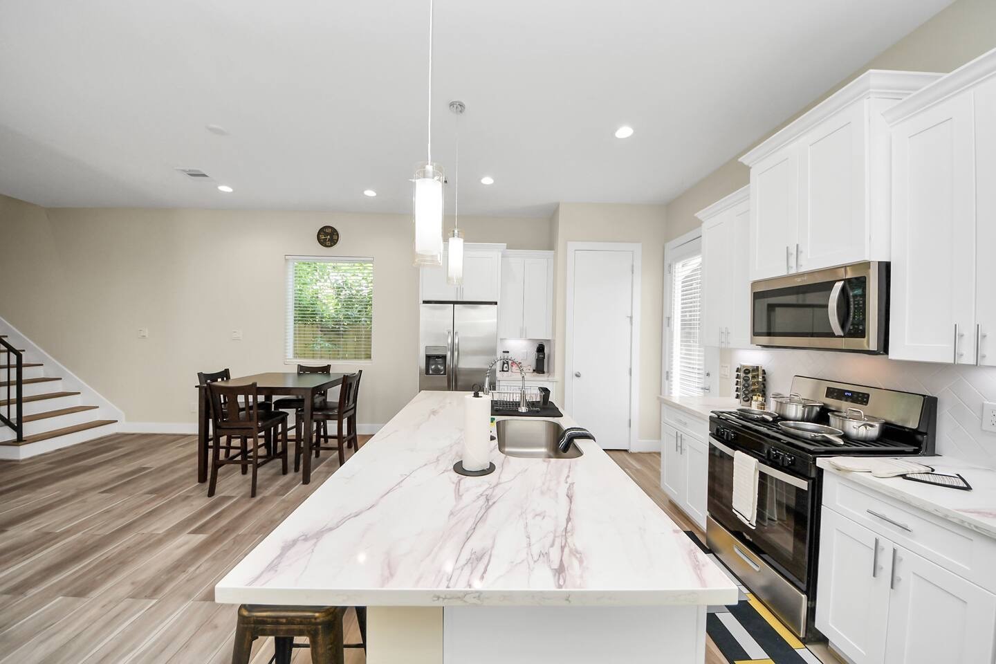 5935 Beall Street, Unit D Houston, TX 77091 - Photo 16 of 50 a kitchen with stainless steel appliances granite countertop a stove top oven a sink a dining table and chairs with wooden floor