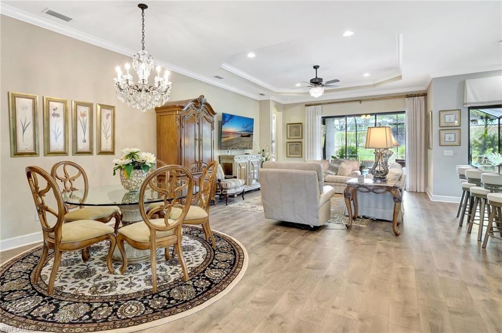 8558 Maggiore Court Naples, FL 34114 - Photo 11 of 50 a living room with dining table and a chandelier