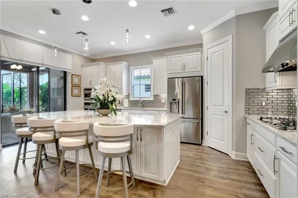 a large kitchen with kitchen island granite countertop a large counter top stainless steel appliances and cabinets