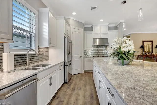 a kitchen with stainless steel appliances granite countertop a stove and a refrigerator