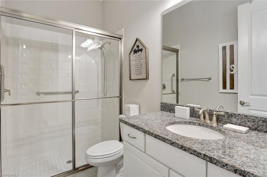 8558 Maggiore Court Naples, FL 34114 - Photo 31 of 50 a bathroom with a granite countertop sink toilet and shower