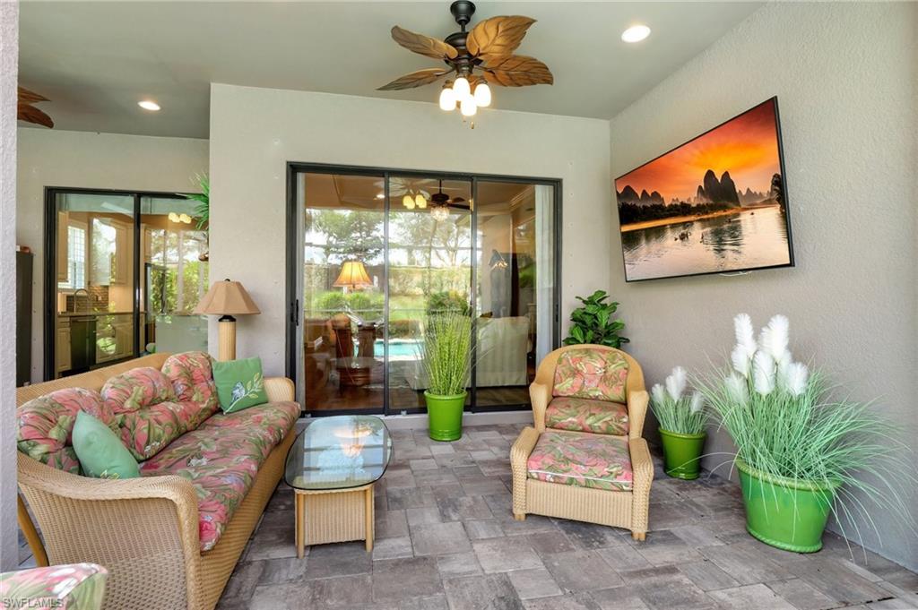 8558 Maggiore Court Naples, FL 34114 - Photo 37 of 50 a living room with furniture a chandelier and a large window