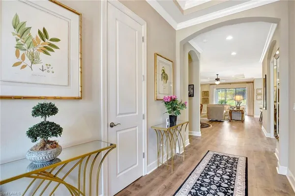 a living room with furniture kitchen view and a chandelier