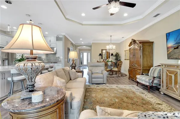 a living room with dining table and a chandelier