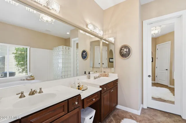 a bathroom with a double vanity sink a mirror and a bathtub
