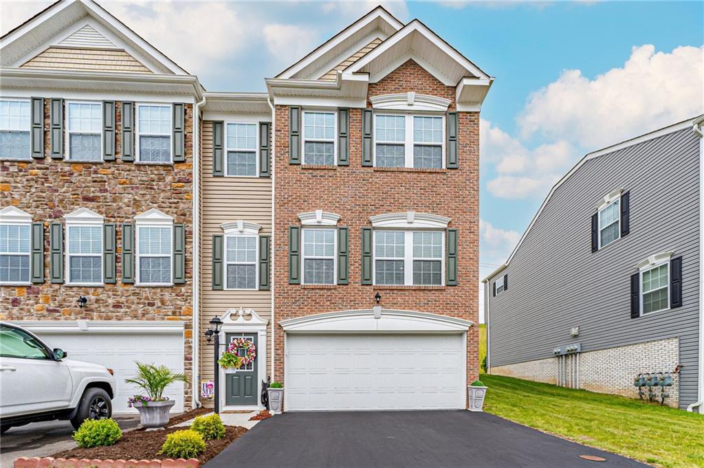 a front view of a house with a garden and trees