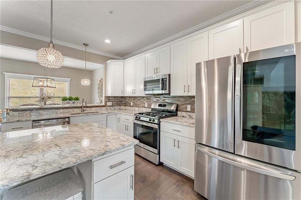 331 Trinity Way Wexford, PA 15090 - Photo 6 of 50 a kitchen with stainless steel appliances granite countertop a refrigerator a stove and a sink with wooden floor