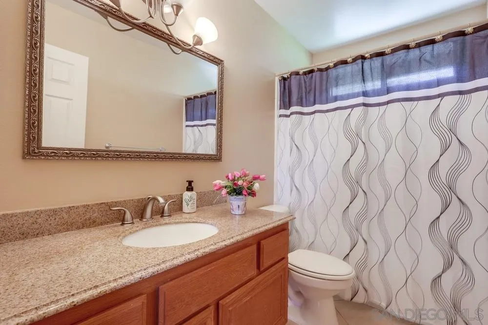 11746 Springside Road San Diego, CA 92128 - Photo 20 of 25 a bathroom with a granite countertop sink and a mirror
