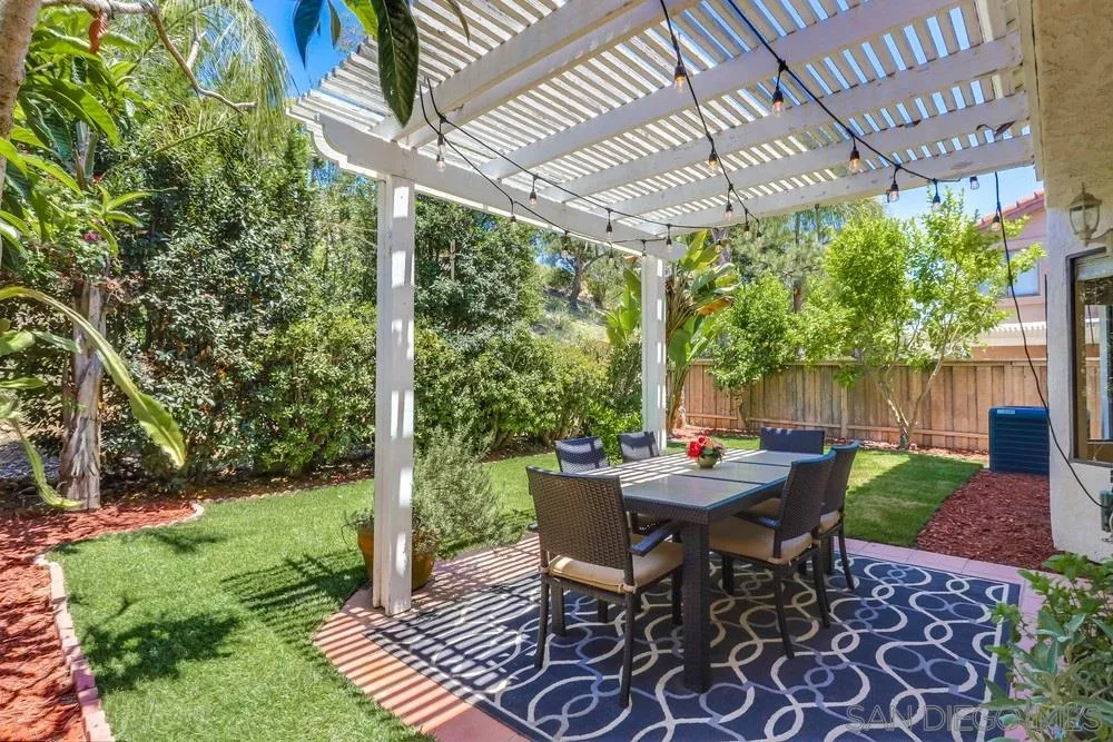 11746 Springside Road San Diego, CA 92128 - Photo 23 of 25 a view of a patio with table and chairs next to a yard