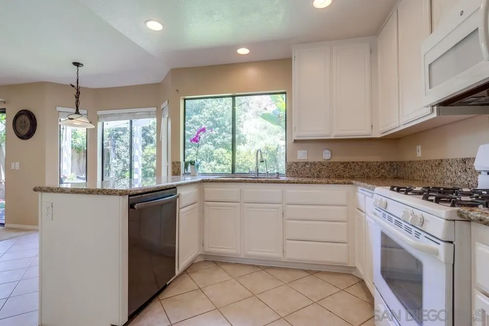 11746 Springside Road San Diego, CA 92128 - Photo 10 of 25 a kitchen with granite countertop white cabinets and white appliances