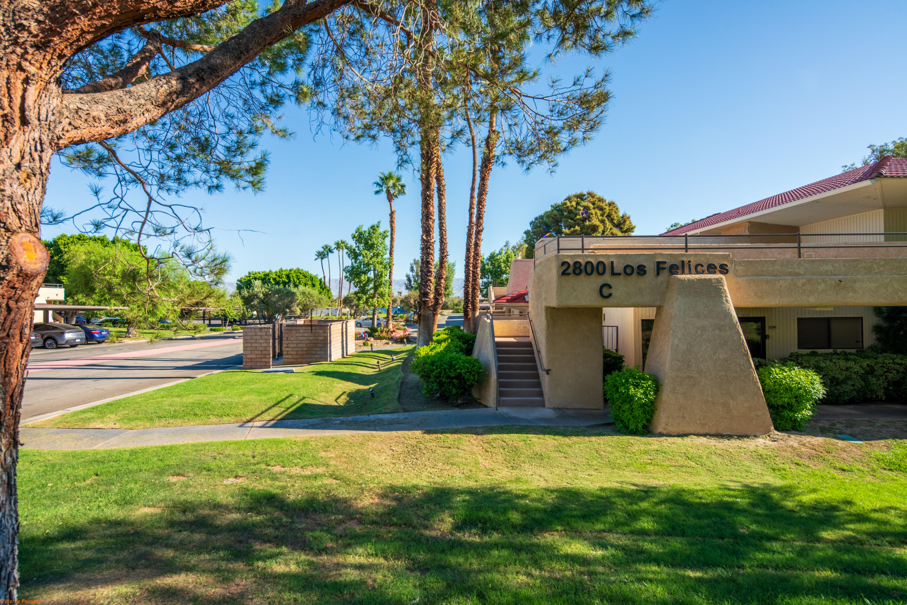 2800 Los Felices Circle North, Unit 107 Palm Springs, CA 92262 - Photo 1 of 18 a front view of a house with garden