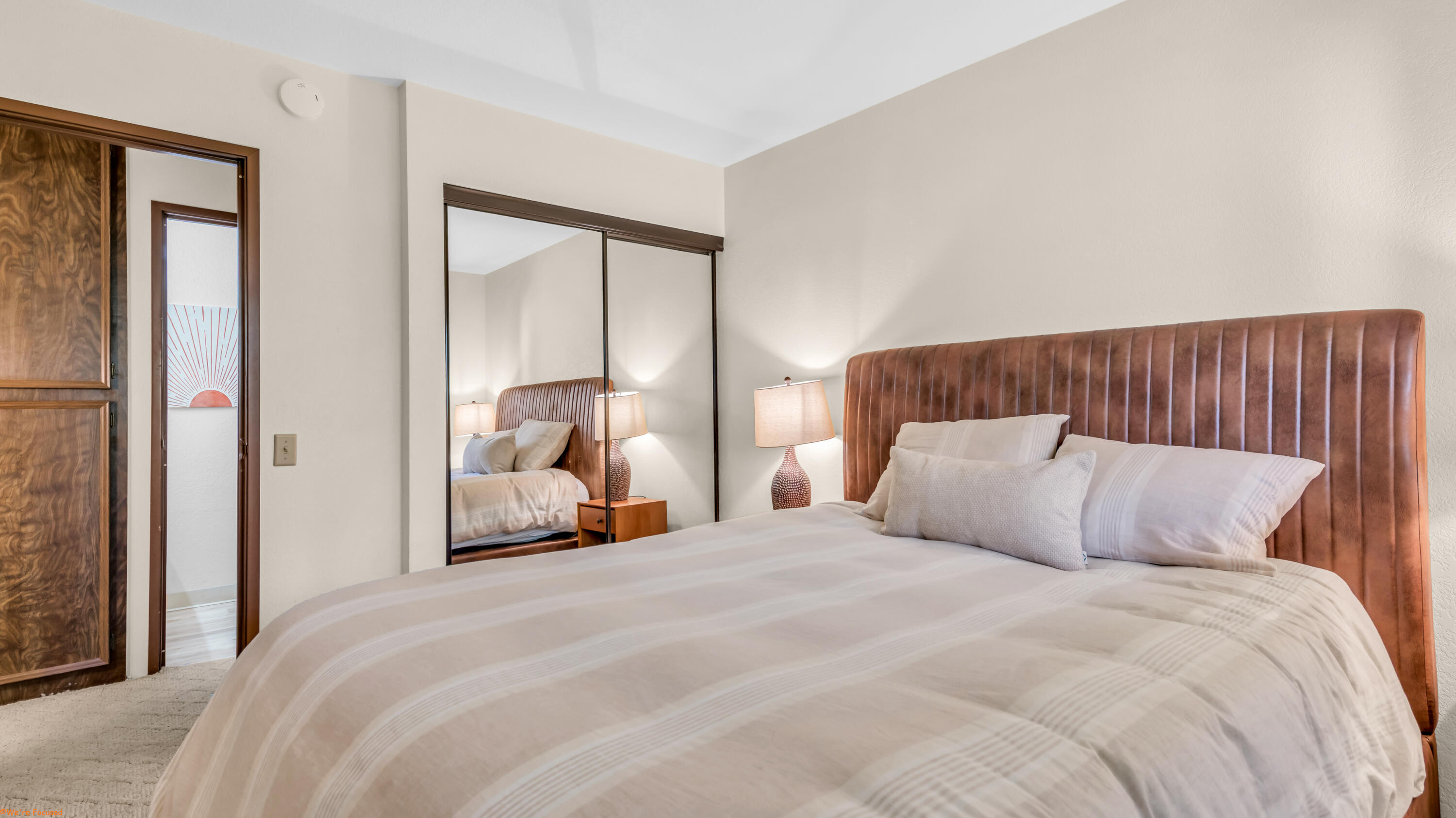 2800 Los Felices Circle North, Unit 107 Palm Springs, CA 92262 - Photo 15 of 18 a bedroom with a large bed and a large mirror