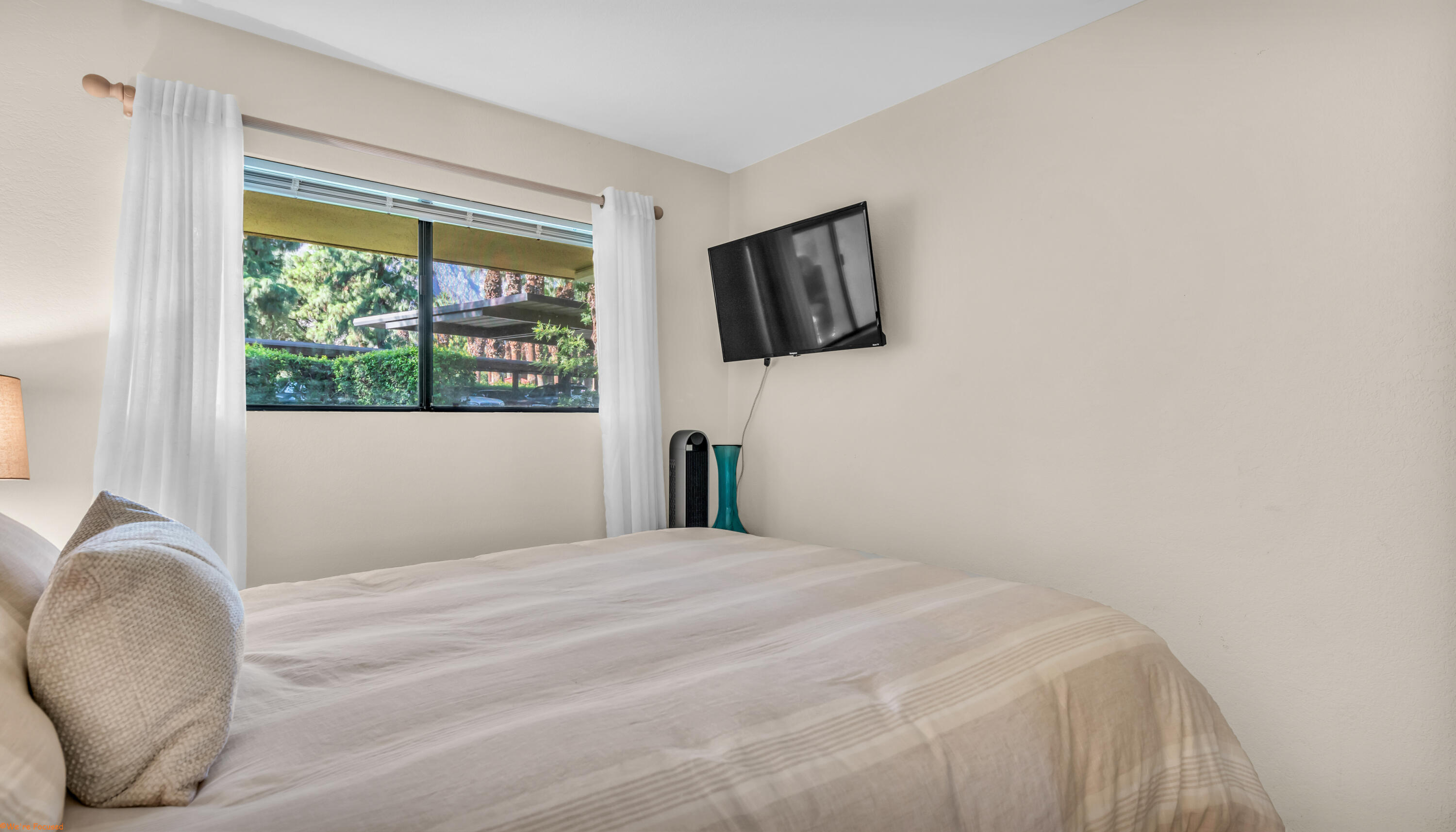 2800 Los Felices Circle North, Unit 107 Palm Springs, CA 92262 - Photo 16 of 18 a bedroom with a bed and a window