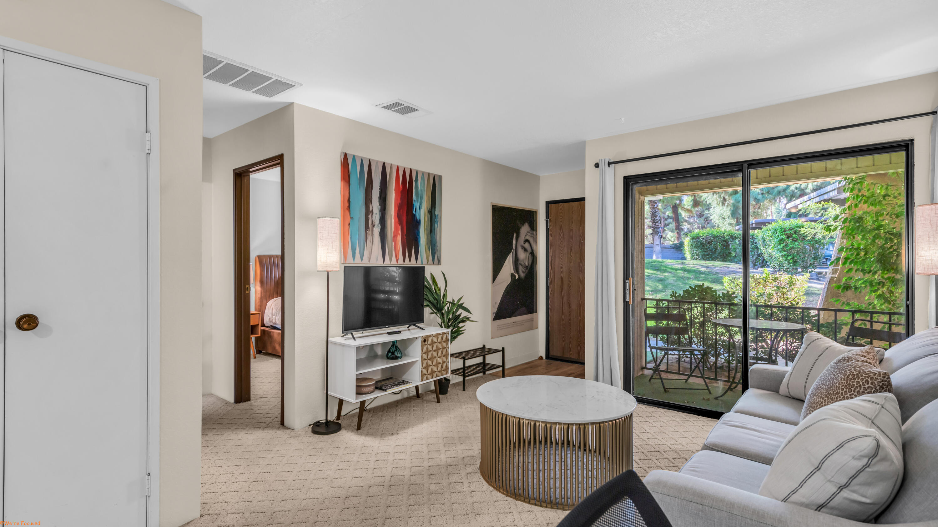 2800 Los Felices Circle North, Unit 107 Palm Springs, CA 92262 - Photo 5 of 18 a living room with furniture and a large window