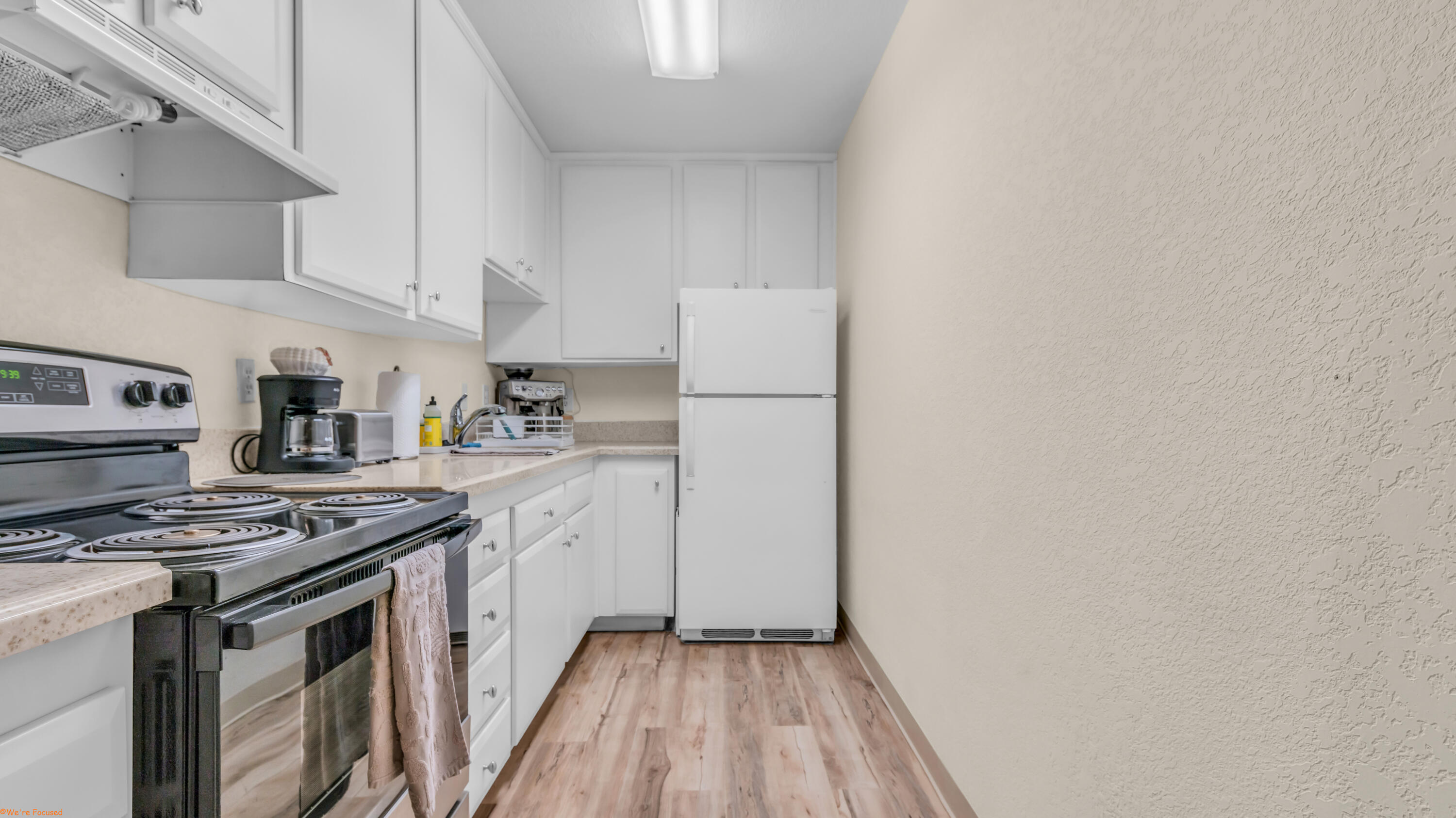 2800 Los Felices Circle North, Unit 107 Palm Springs, CA 92262 - Photo 8 of 18 a kitchen with cabinets appliances a sink and a counter space