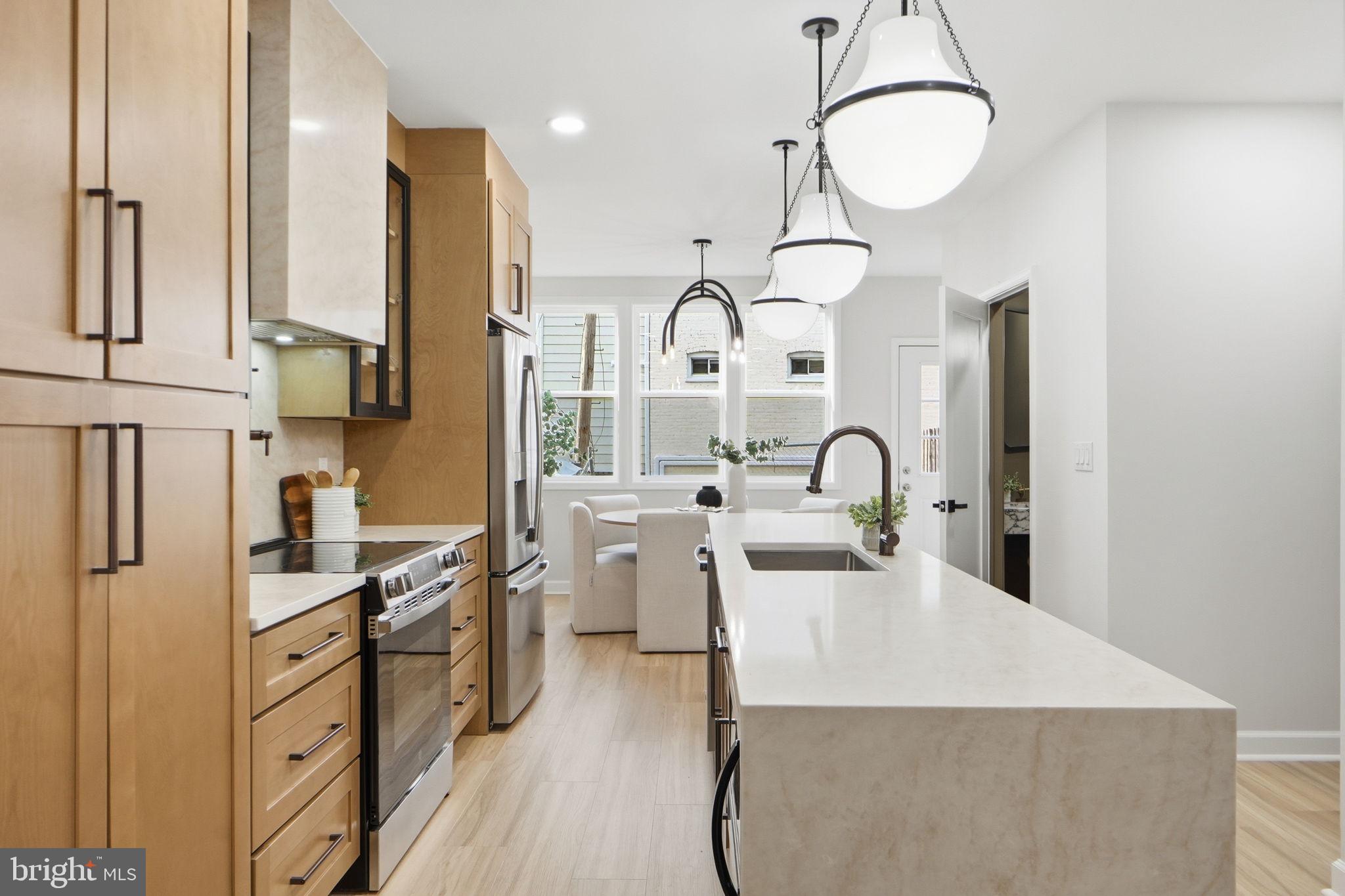 1412 Trinidad Avenue Northeast Washington, DC 20002 - Photo 12 of 47 a kitchen with stainless steel appliances granite countertop a stove a sink dishwasher and white cabinets with wooden floor