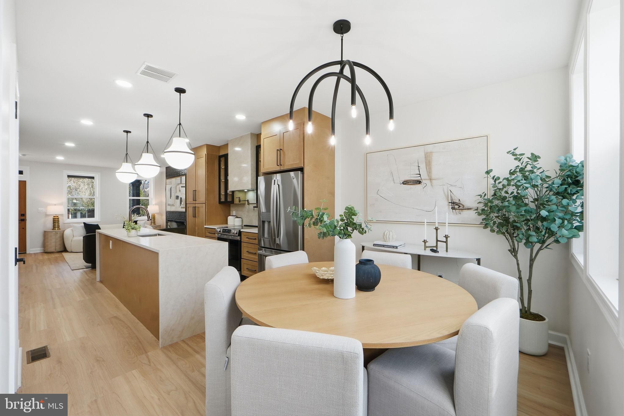 1412 Trinidad Avenue Northeast Washington, DC 20002 - Photo 20 of 47 a dining room with kitchen island stainless steel appliances and chandelier