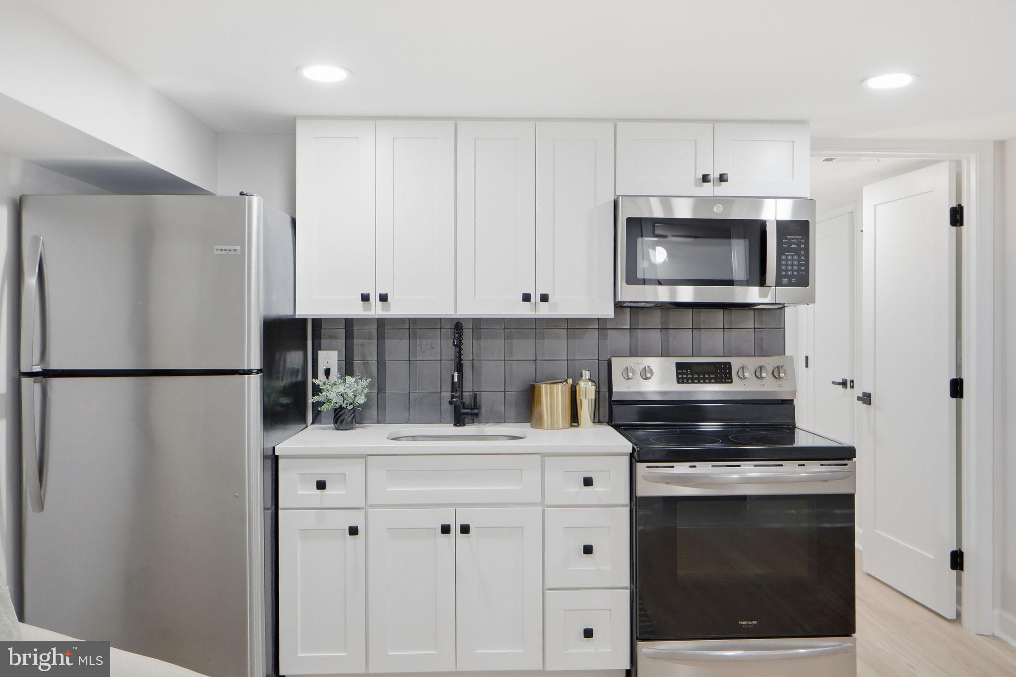 1412 Trinidad Avenue Northeast Washington, DC 20002 - Photo 43 of 47 a kitchen with white cabinets stainless steel appliances and sink