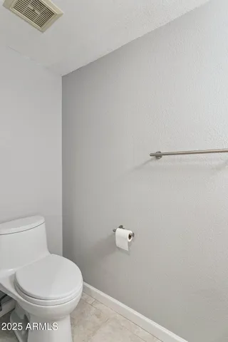 a white toilet sitting next to a shower