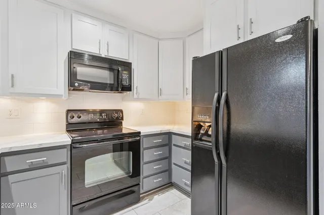 a kitchen with stainless steel appliances granite countertop a refrigerator stove and microwave