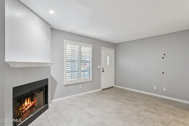 a view of an empty room with a fireplace and a window