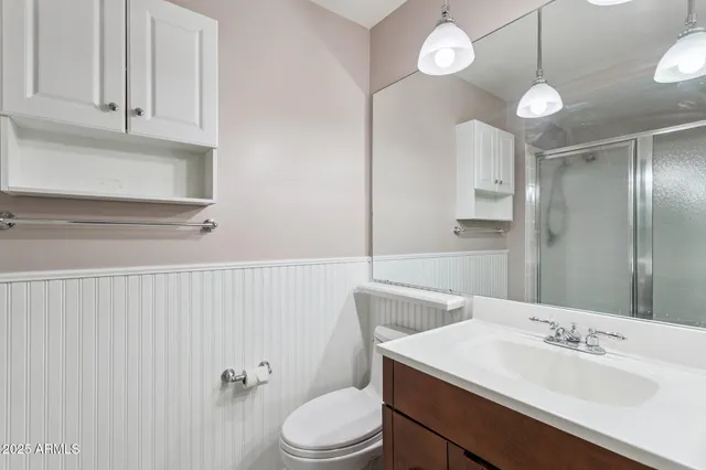 a bathroom with a sink vanity mirror and toilet